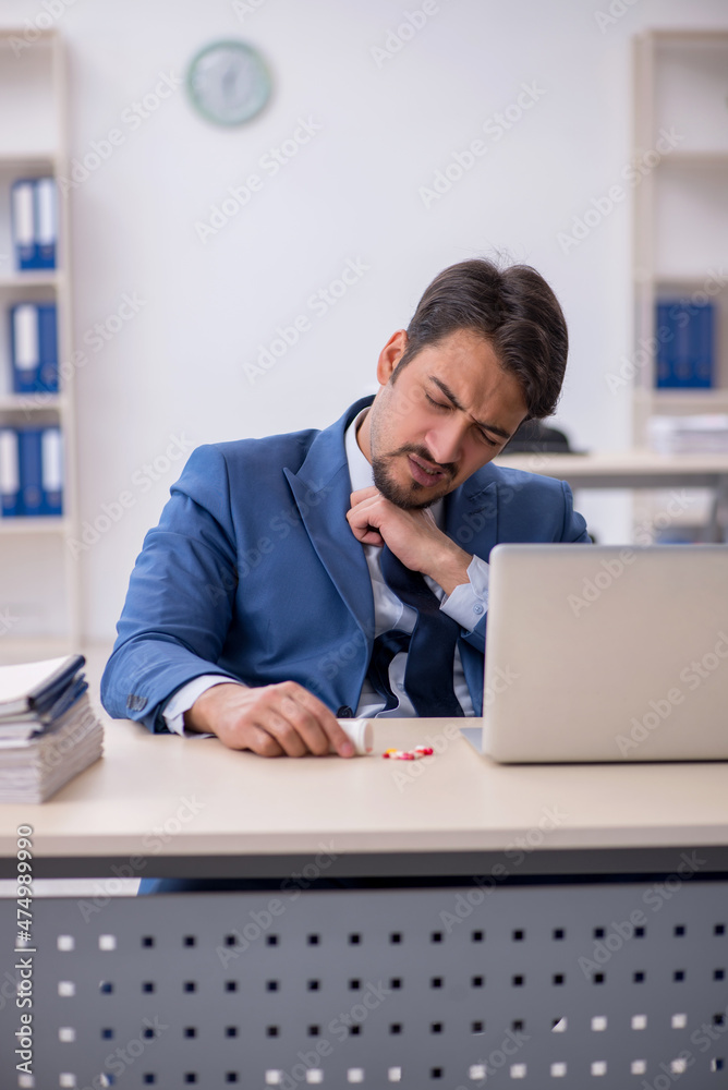 Young male employee suffering at workplace Young male employee suffering at workplace