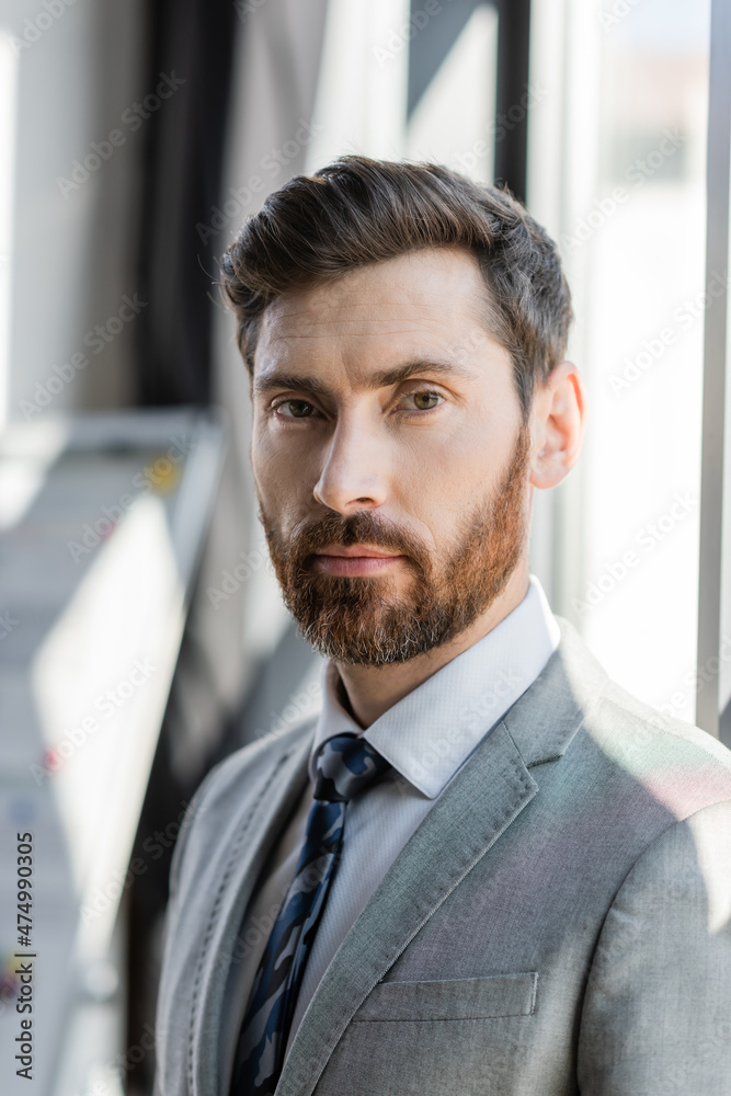 Businessman in formal wear looking at camera in office.