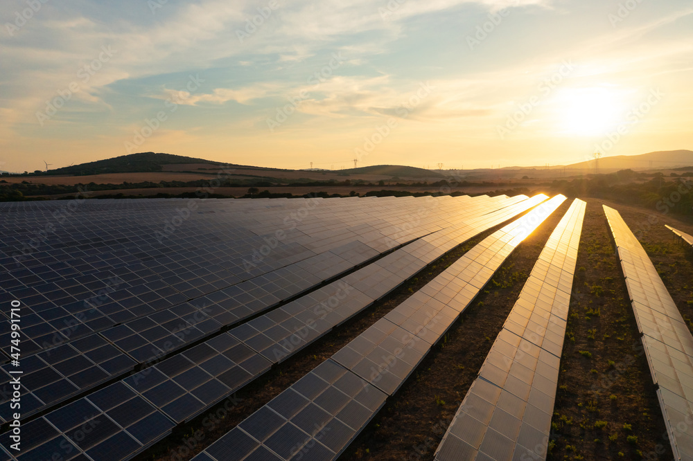 Solar panel farm under sunset sky reflecting light. Solar panel farm under sunset sky reflecting light.