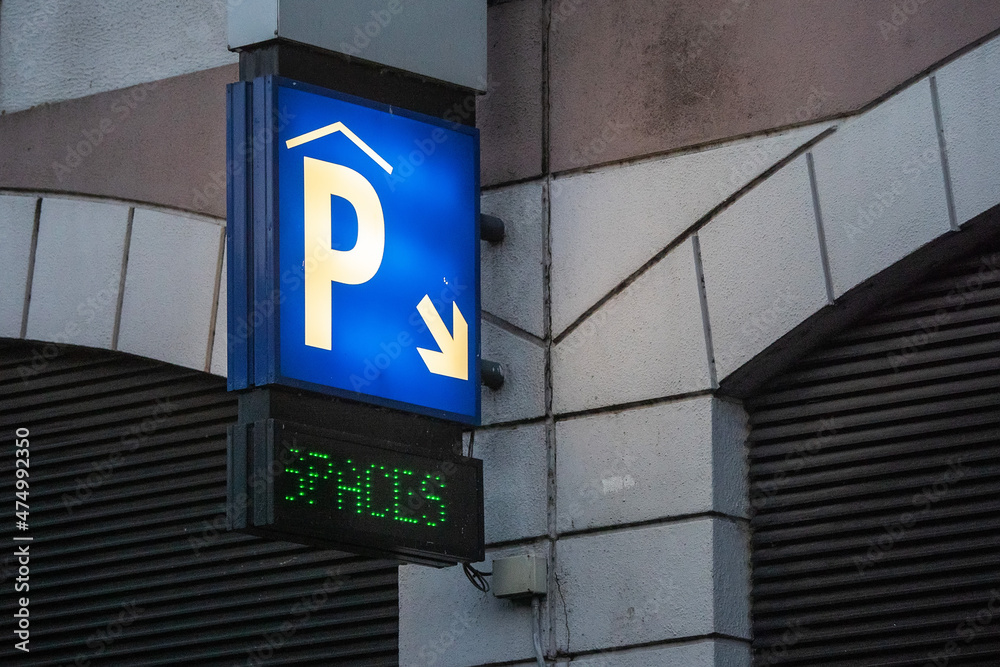 Naklejka premium Sign P for parking and direction arrow and spaces on a exterior of a building