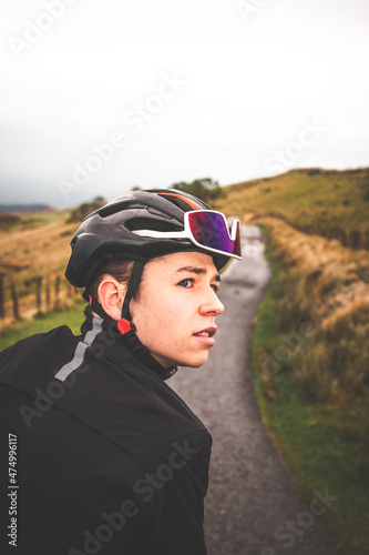 Young caucasian cyclist looking back on a mountain road. © Jorge Argazkiak