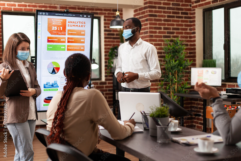 Business leaders showing marketing presentation working at company strategy with businessteam in startup office. Diverse group of people wearing medical face mask to prevent infection with covid19 Business leaders showing marketing presentation working at company strategy with businessteam in startup office. Diverse group of people wearing medical face mask to prevent infection with covid19