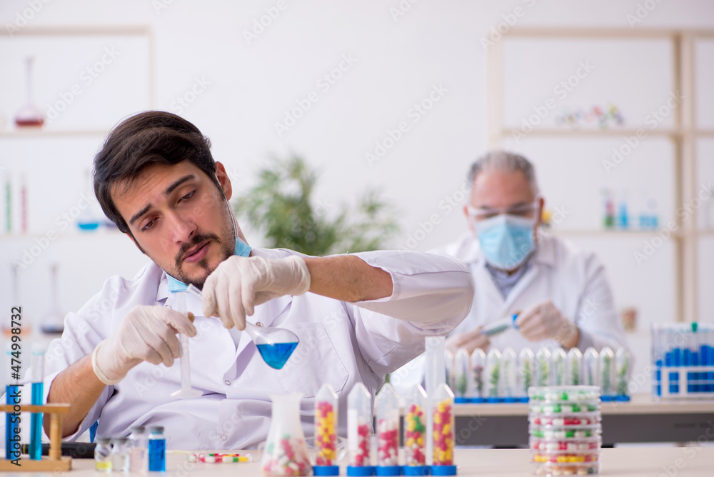 Two male chemists in drugs synthesis concept at the lab Two male chemists in drugs synthesis concept at the lab
