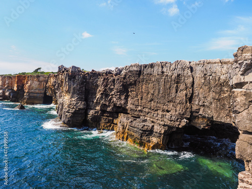 Boca do Inferno, high cliffs feature a natural archway or open cave, created by pounding waves. Steep rocks illuminated by the setting sun. Famous tourist spot, Atlantic ocean shore, Portugal, Cascais