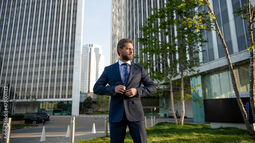 charismatic mature businessman in suit outside the office, business