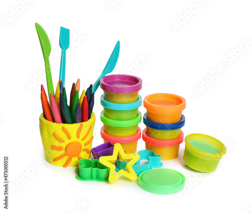 Set of bright play dough with tools and colorful pencils on white background