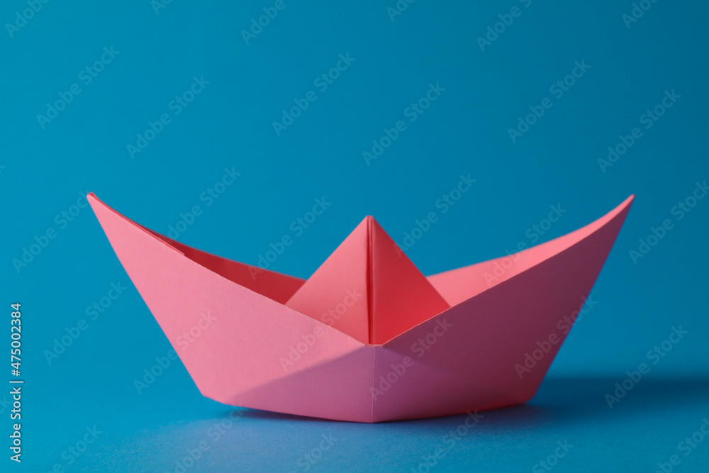 Handmade pink paper boat on light blue background. Origami art Handmade pink paper boat on light blue background. Origami art