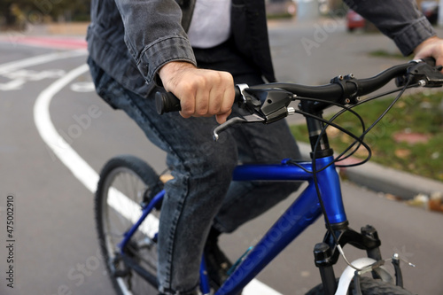 Man riding bicycle on lane in city, closeup