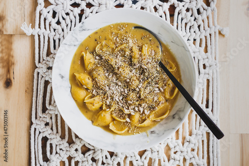 vegan creamy shell pasta with pumpkin sauce and seeds topping, healthy plant-based food