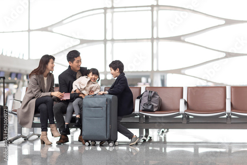 Happy young family waiting for flight at the airport