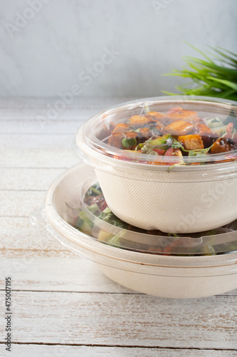 A view of a stack of salad bowls in to-go containers.