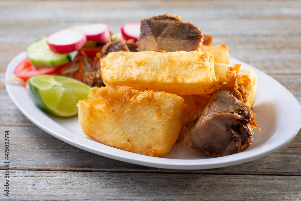 Foto de A view of a plate of yuca frita con chicharron, which is fried