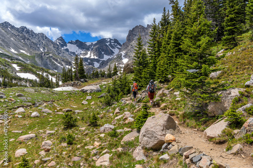 Mountain Trail - Two well-equipped mountaineers hiking on Pawnee Pass Trail towards rugged Indian Peaks on a sunny Summer day. Indian Peaks Wilderness, Colorado, USA. photo