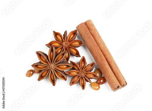 Dry anise stars and cinnamon stick on white background, top view