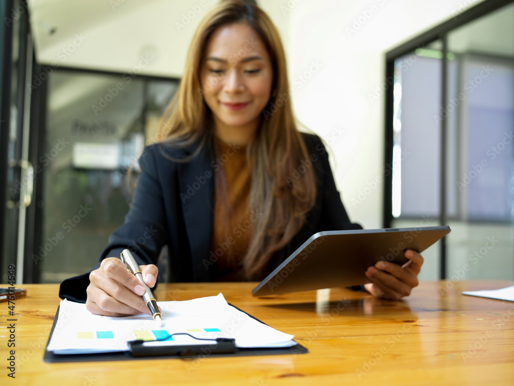 Businesswoman examines financial data from her financial report Businesswoman examines financial data from her financial report