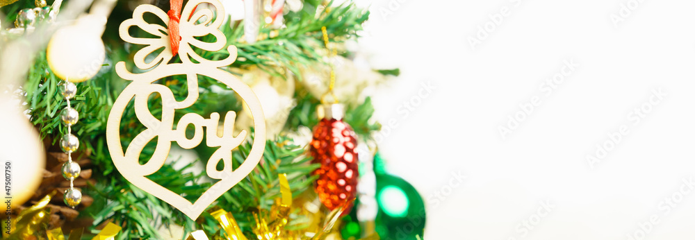 Closeup of colorful Christmas ornament decoration with word Joy among red green bauble, pine cone, candy cane on white background. Banner, Copy space, Happiness, Love, joy, Peace, Hope, New year 2022
