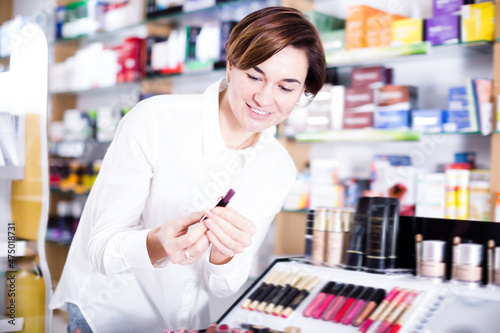 Pretty female looking for make-up items in pharmacy