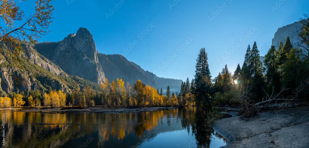 Panoramic View of Fall Season Color Trees Reflected on Water With Mountains in the Background