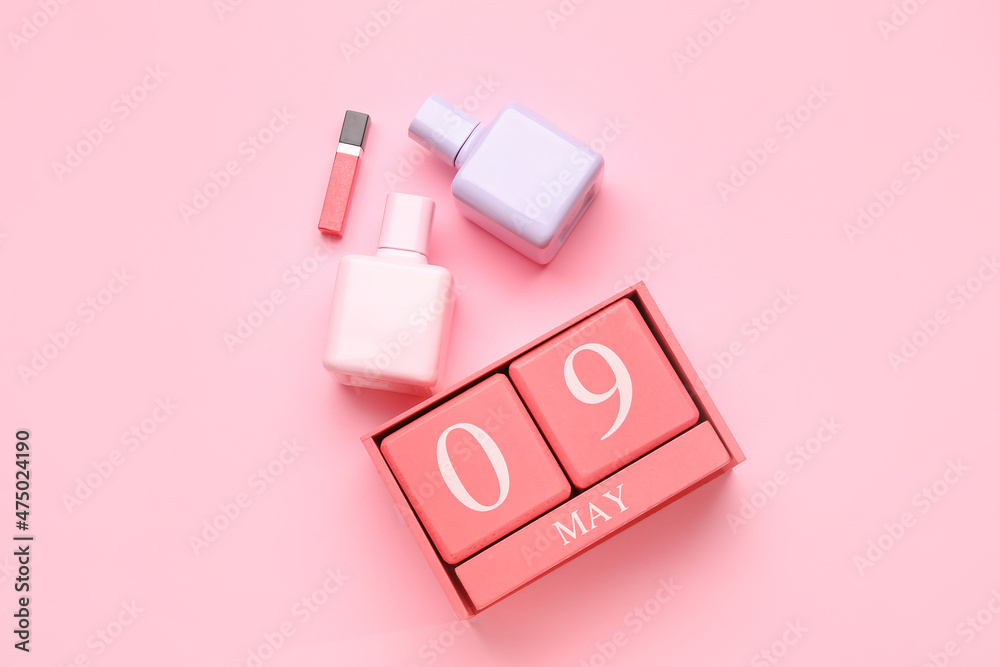 Calendar with date of May 9 and cosmetics on color background Calendar with date of May 9 and cosmetics on color background