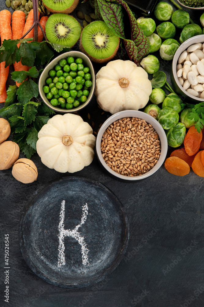 Foods high in vitamin K on dark background.