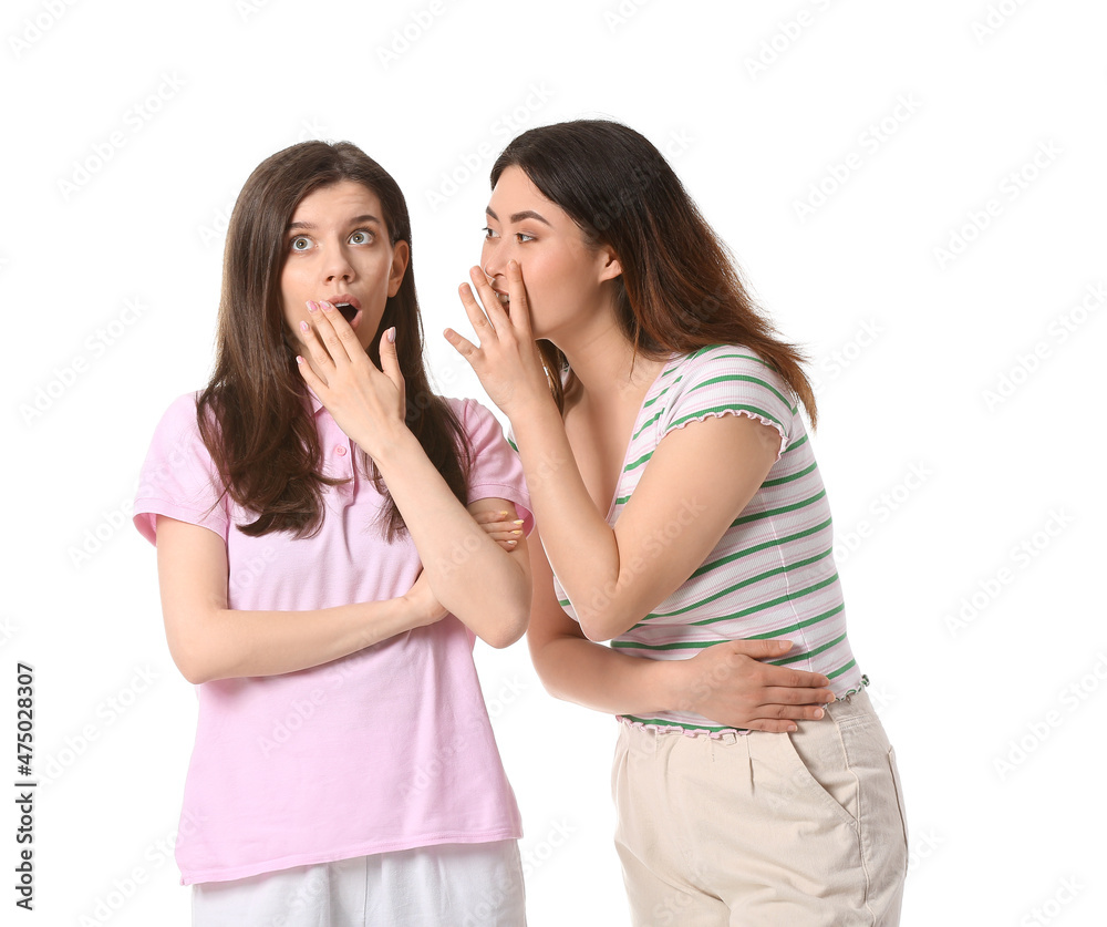 Young gossiping women on white background