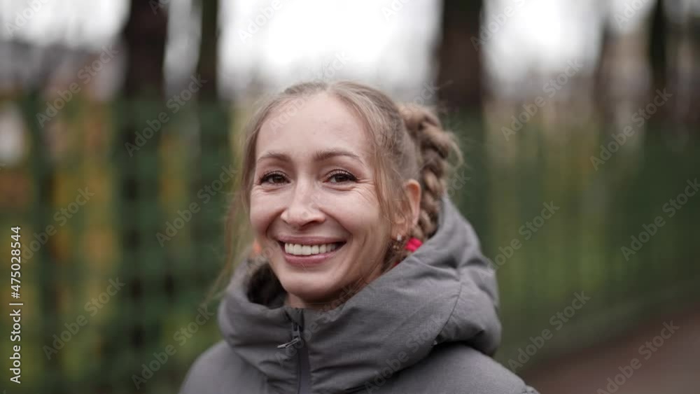 portrait of happy middle-aged woman with funny braid hairstyle walking in street in autumn portrait of happy middle-aged woman with funny braid hairstyle walking in street in autumn