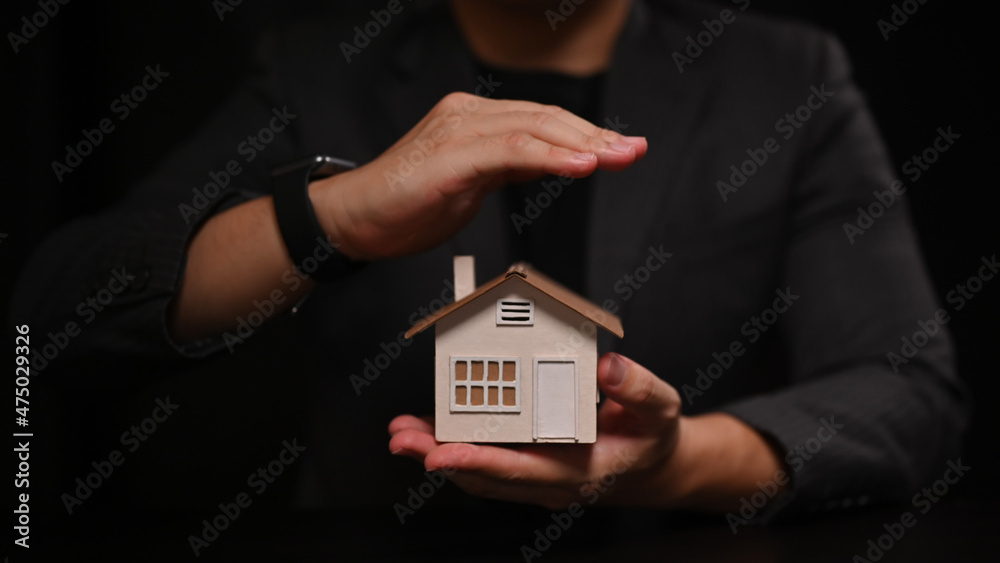 Close up view man hands protecting house model. Property insurance concept. Close up view man hands protecting house model. Property insurance concept.