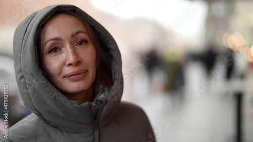 woman is drinking hot glintwein on street, closeup portrait of adult female passer in winter day photo