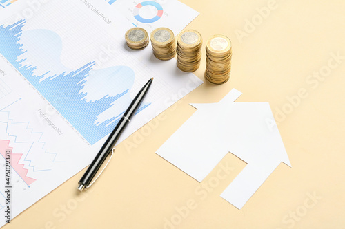 Paper house with coins, pen...