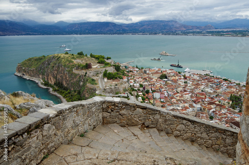 Picturesque landscape scenic view of Peloponnes coastal town city of Nauplion Nafplion in Greece with historic ancient old city skyline house building facades, rocks and fortress overlooking bay photo