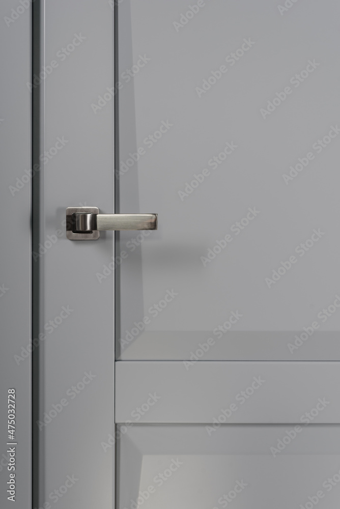 Stainless stylish door knob on grey wooden door Stainless stylish door knob on grey wooden door