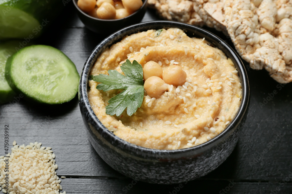 Bowl with delicious hummus on table, closeup Bowl with delicious hummus on table, closeup