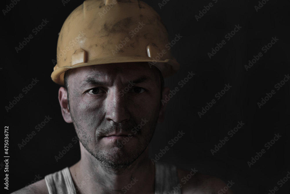 Portrait miner in helmet and undershirt with dirty face. Portrait miner in helmet and undershirt with dirty face.