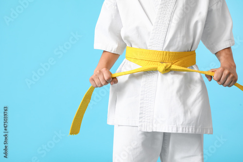 Little boy in karategi on color background