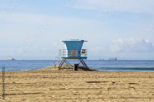 Lifeguard tower on beach with cargo ship in distance