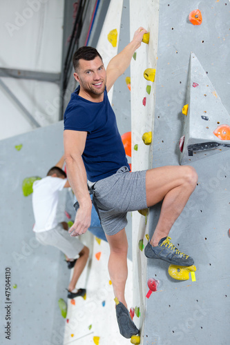 man climbing a rock wall indoor
