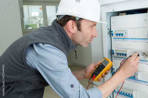 portrait of electrician inspecting live circuits