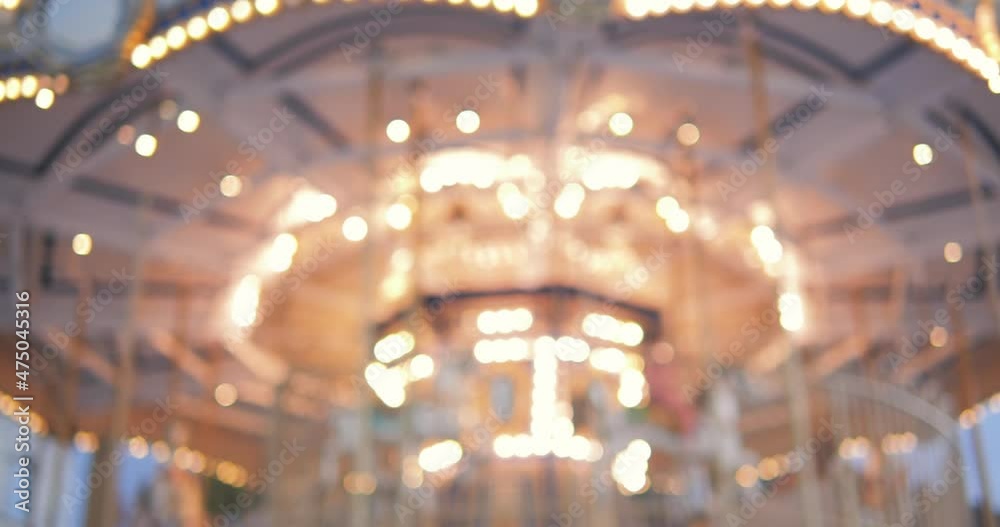 Blurred incredible colorful flashing light of carousel carnival fair merry go round circus horse ride at amusement park 