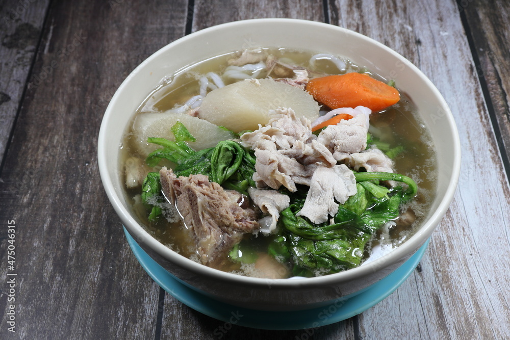 Hot clear soup of streaky pork and fresh vegetable serving in the bowl. Famous soup menu in Chinese restaurant. Hot clear soup of streaky pork and fresh vegetable serving in the bowl. Famous soup menu in Chinese restaurant.