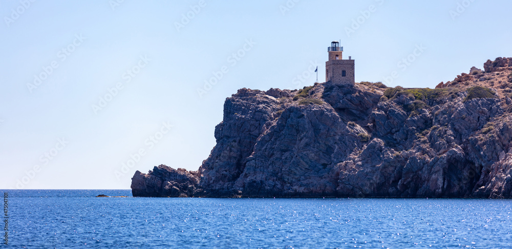 Lighthhouse building on a rocky cliff. Ios island Greece. Cyclades.