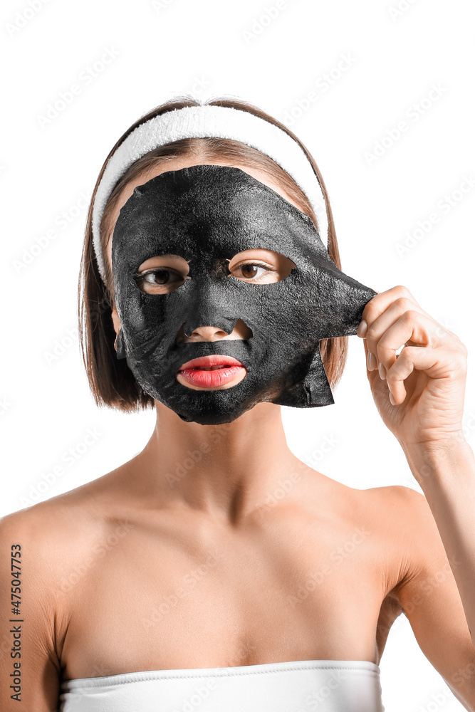 Young woman with activated charcoal mask on her face against white background Young woman with activated charcoal mask on her face against white background
