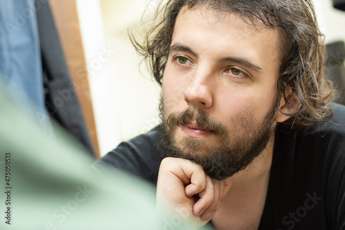 Portrait of a young dark-haired man listening to the interlocutor. Selective focus. The concept of communication and dialogue photo