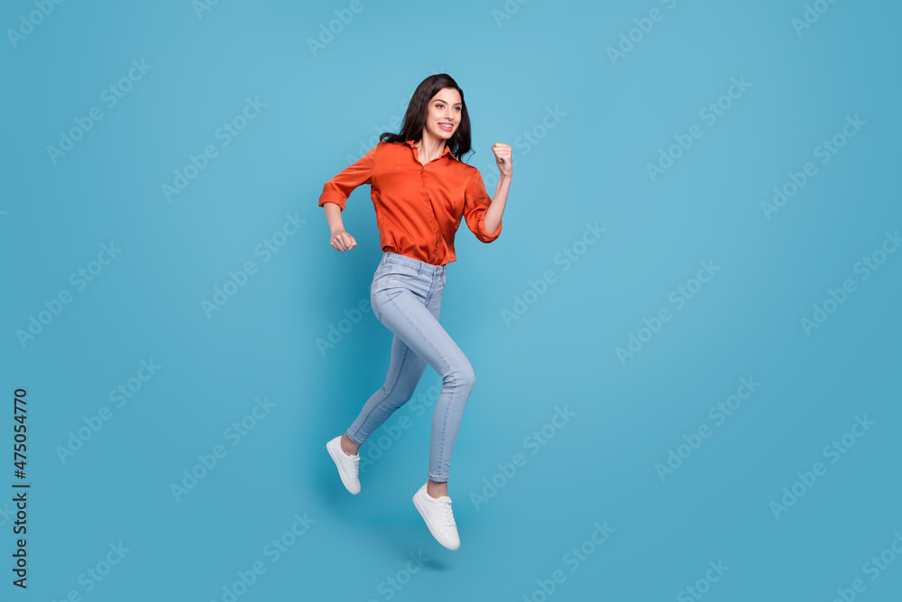 Full length body size view of attractive cheery motivated girl jumping running isolated over bright blue color background