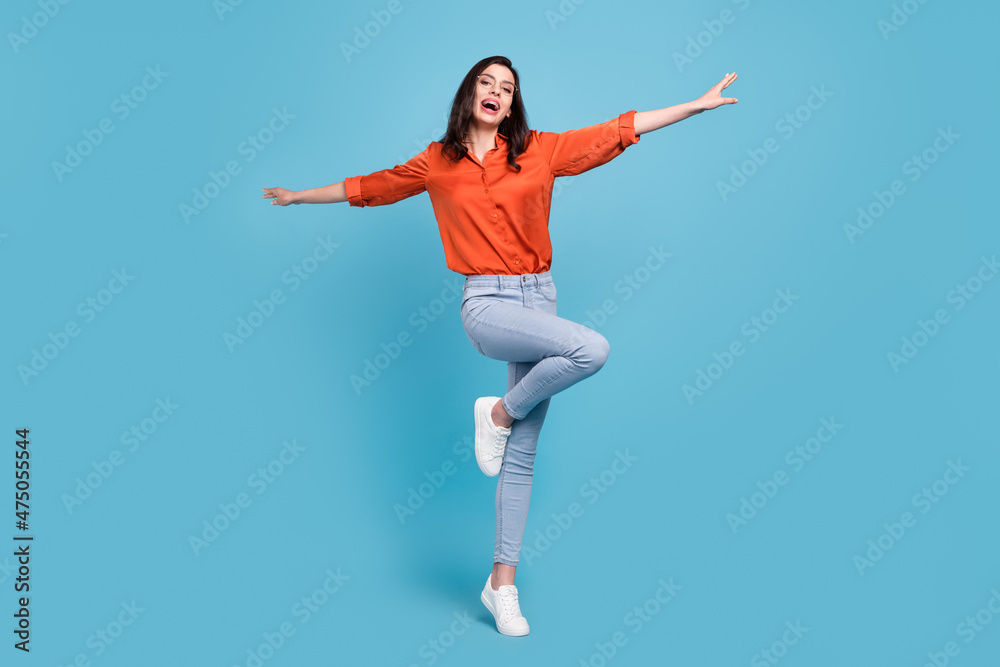 Full length body size view of attractive cheerful girl flying like plane having fun isolated over bright blue color background