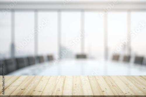 Blank wooden office desk with light furnished meeting room with big window on background, mock up © Pixels Hunter