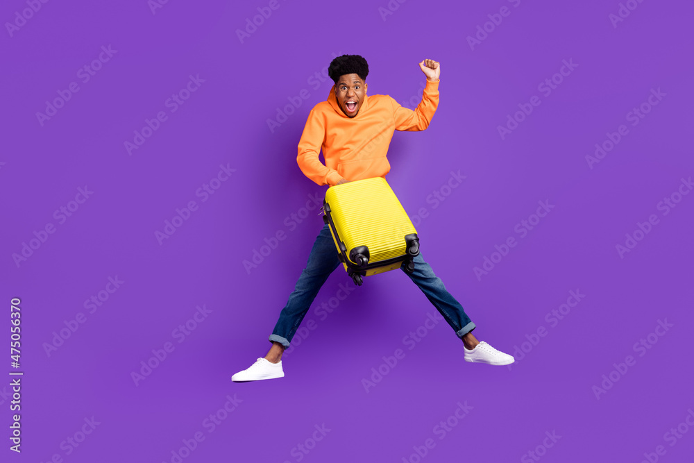 Full length body size view of attractive trendy cheery lucky guy jumping holding bag isolated over bright violet purple color background