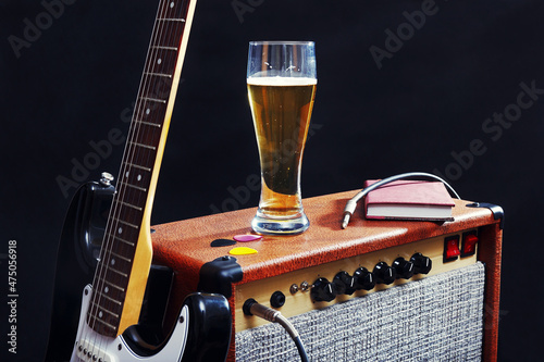 Wall Mural Tube amplifier for guitar with black guitar, glass of beer and notepad on black background