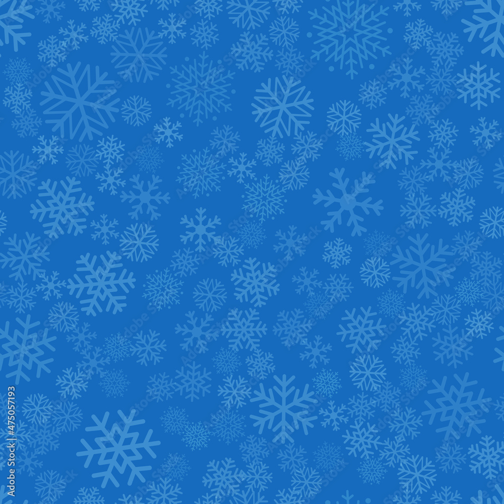 Seamless winter background consisting of snowflakes of different shapes placed chaotically. Snowflakes placed on blue background. Christmas and new year symbol and mood.