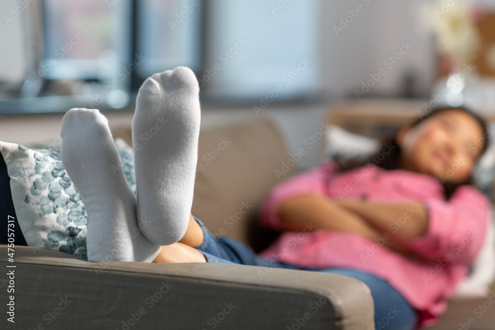 Obraz premium people and leisure concept - close up of feet of woman sleeping on sofa at home