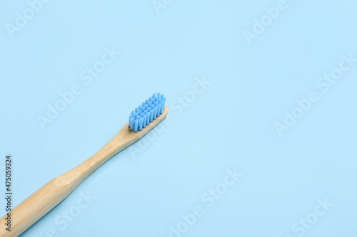 Wooden toothbrush on blue background  closeup